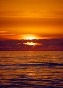 Solen er på vej i havet hvor den kigger gennem en af de sidste skyer, de smukke dybrøde og orange farver danne en smuk kontrast om sceneriet
