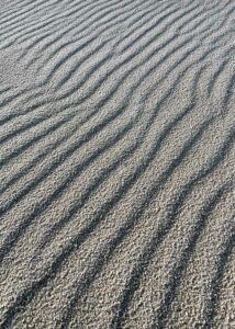 Mønstrene i sandet danner symmetriske og asymetriske mønstre i en skøn blanding