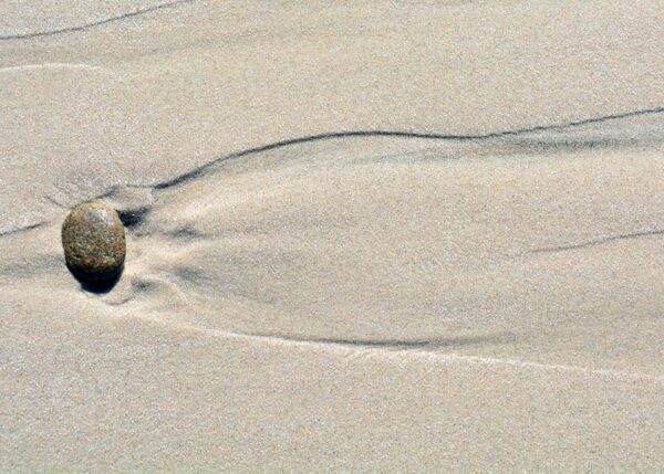 Sten i sandet trækker flotte spor i sandet når vandet forsvinder tilbage i havet