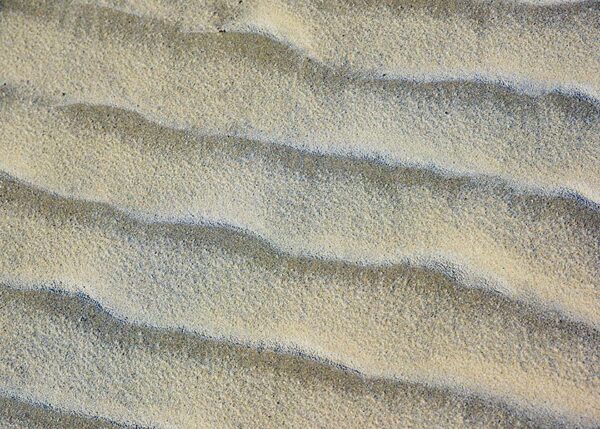 Vinden og vandet har tegnet dragende mønstre i sandet på stranden