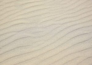 Brudte kurver i sandet på stranden - fantastisk mønstre opstår og forsvinder igen