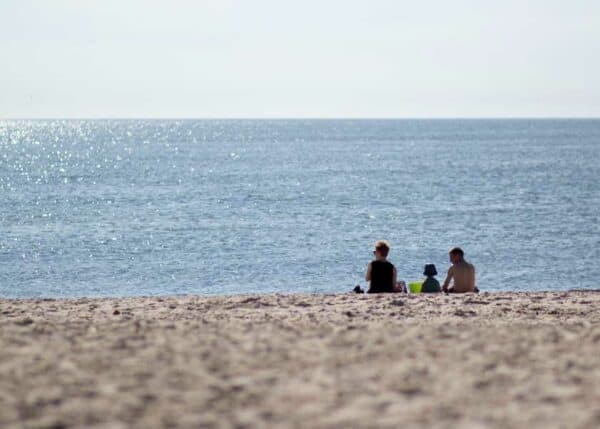 Fantastisk sommerdag, familien har slået sig ned ved strandkanten - havet synes endeløst