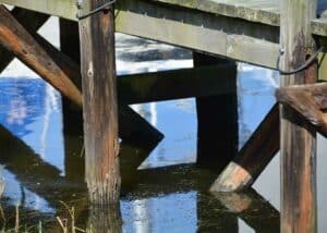 Den gamle træbro er mærket efter årene i vandet, stolperne er ormeædte efter de mange år