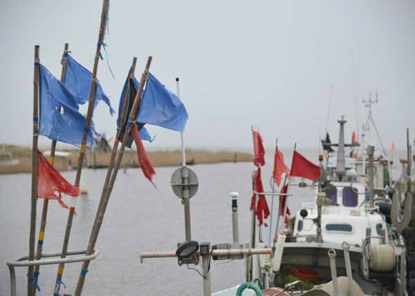 Tyskerhavnen i Hvide Sande fiskernes joller ligger ved kajen, bøjernes flag vejrer i den sagte vind
